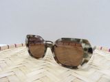 un gros plan sur une paire de lunettes de soleil posée sur un panier tressé