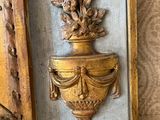 a gold vase with flowers on it next to a picture frame