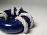 a blue and white donut that is sitting on a table