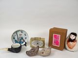 une petite collection de figurines miniatures comprenant une horloge, une théière, une tasse à thé et une théière