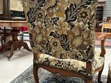 an antique chair with a floral upholstered back and a floral upholstered back