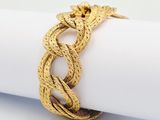 an image of a close up of a gold bracelet on a napkin
