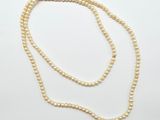 un collier de perles blanches avec un fermoir en or