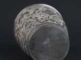 a close up of a silver cup on a black background