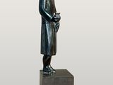 bronze statue of a woman holding a bird on a pedestal