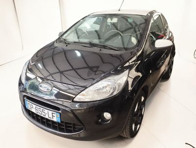 une voiture noire garée dans une pièce blanche