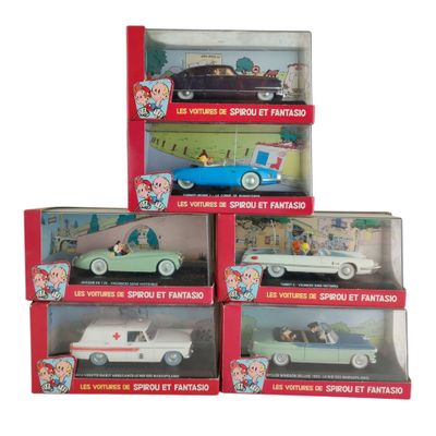 quatre petites voitures dans une vitrine, avec un homme dans une voiture