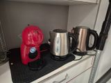 une cafetière rouge posée sur le plan de travail de la cuisine