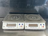 two electronic scales sitting on top of a metal counter top