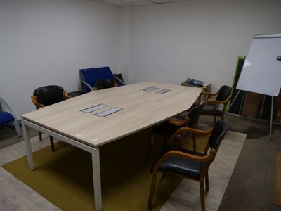 des tables et des chaises dans une pièce où se trouve un tableau blanc accroché au mur