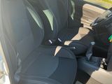 l'intérieur d'une petite voiture avec des sièges noirs et une ceinture de sécurité verte