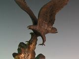 une statue représentant un aigle perché sur une souche d'arbre