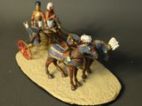 a figurine of two people riding in a horse drawn carriage