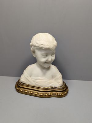 un gros plan sur la statue d'un enfant posée sur une table