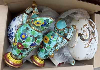 de nombreux vases rangés dans une boîte posée par terre
