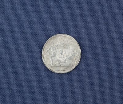 un gros plan d'une pièce d'argent posée sur un tissu bleu