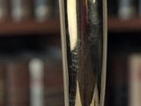 a gold trophy on a table in front of a bookshelf