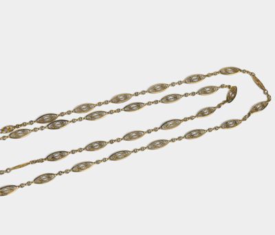 un collier en or composé d'une longue chaîne ornée d'un motif ovale