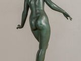 statue of a woman standing on a wooden base with her arms outstretched