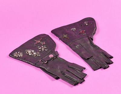 une paire de gants en cuir noir sur fond rose