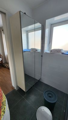 une salle de bains équipée de toilettes, d'un lavabo et d'une cabine de douche