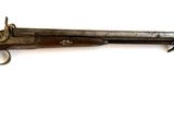 un vieux pistolet avec un canon en bois et une poignée en métal