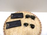 a tray with sunglasses, sunglasses case, and wallet on it