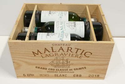 des bouteilles de vin se trouvent dans un coffret en bois sur une table