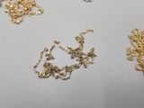 a lot of gold and silver necklaces on a table
