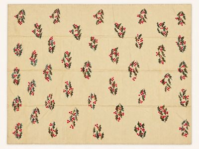 un gros plan sur une nappe ornée de feuilles et de baies de houx