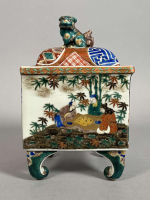 an image of a decorative box with a man sitting on top of it