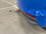 a close up of a blue car in a parking lot