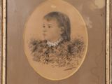 une vieille photo d'un jeune garçon portant une chemise à col, dans un cadre doré
