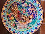 a colorful plate with a bird on it on a table