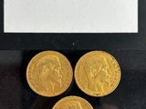 three gold sovereigns in a display case