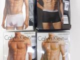 three men ' s underwear are displayed on a table in front of a book