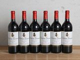 six bouteilles de vin rouge alignées sur une table en bois