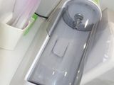 a toothbrush and toothpaste dispenser sitting on a counter