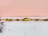 a picture of a gold plated chain with leaves on it