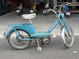 a blue bike parked in a parking lot with a basket on the back of it