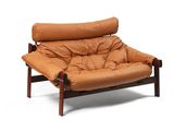 La chaise est en cuir marron et possède une structure en bois