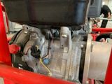 a close up of a small engine on a red cart
