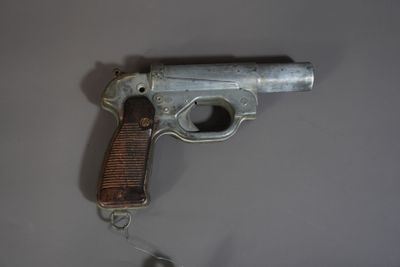 un vieux pistolet accroché au mur à côté d'une souris