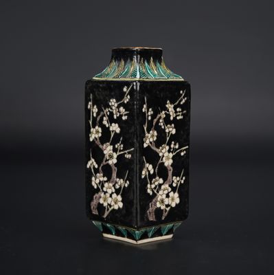 a black and white vase with flowers and birds on it