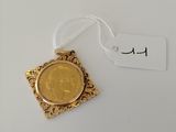 a gold coin with a tag on it sitting on a white surface