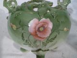 un vase vert orné d'une fleur rose