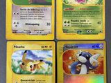 quatre cartes Pokémon empilées les unes sur les autres sur une table
