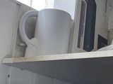 a microwave and a cup on a shelf in a room