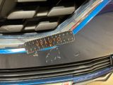 a close up of a car ' s grille with a sticker on it