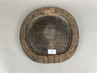 une assiette marron posée sur une table blanche, sur laquelle est apposée une étiquette